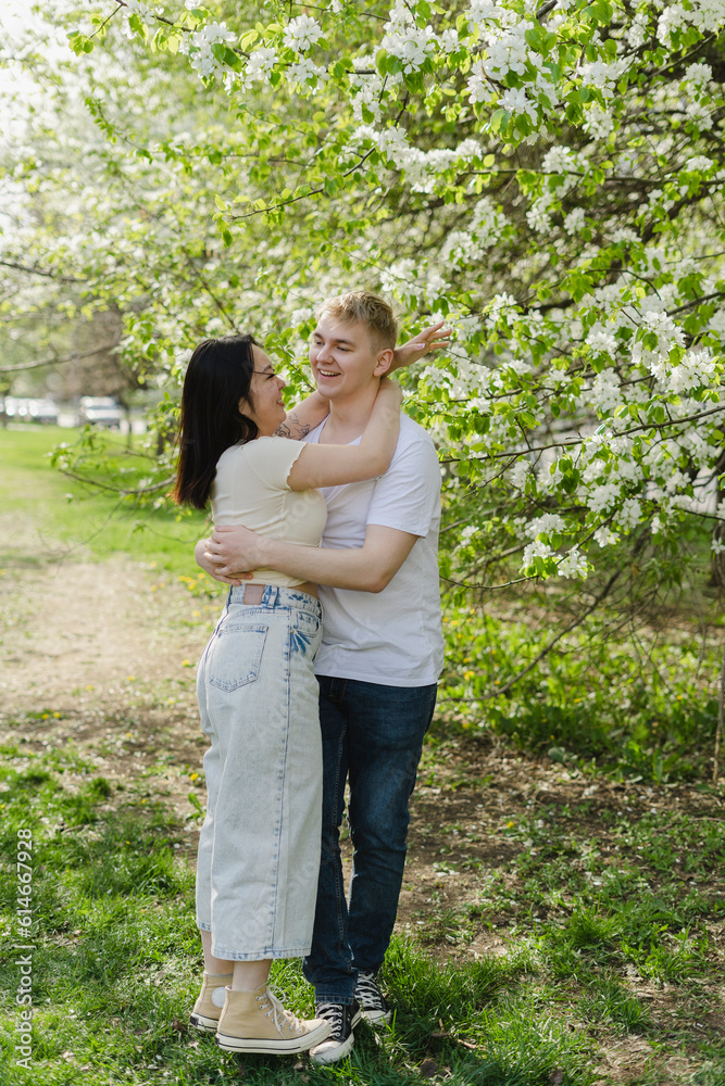 Young couple embracing each other by tree in bloom at park Young couple embracing each other by tree in bloom at park