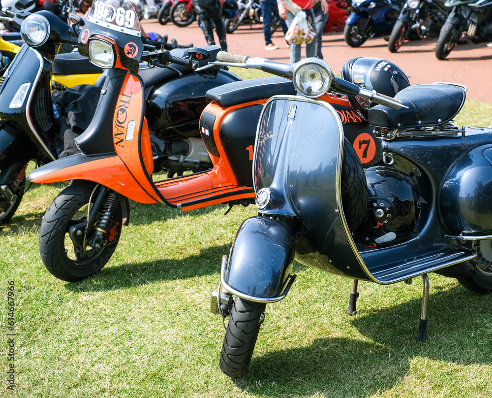 Classic and retro scooters parked on the green in the coastal town of