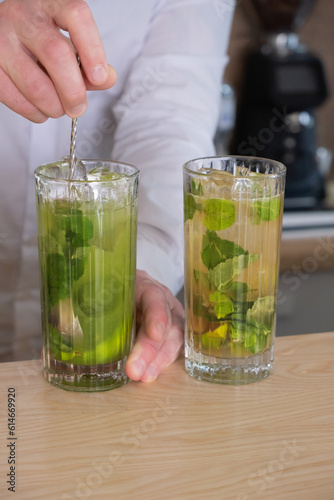 Preparation of a mojito cocktail by a bartender in a cafe. Summer cold drink