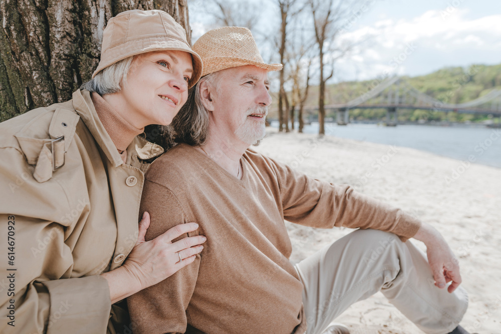 Couple enjoying leisure time sitting at beach Couple enjoying leisure time sitting at beach
