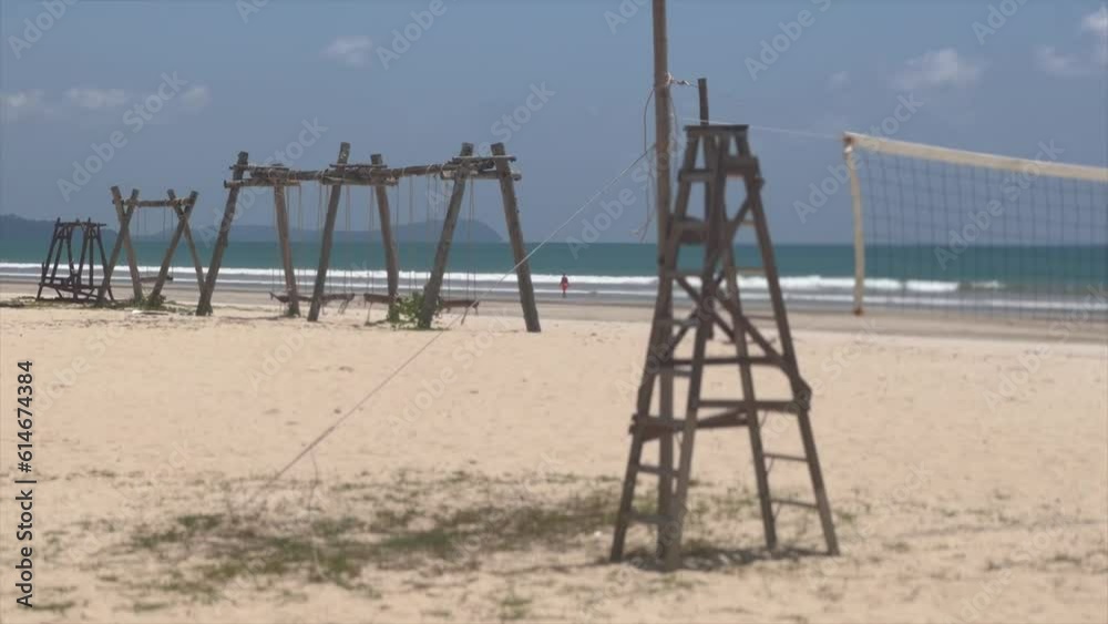 Tropical beach with wooden swings and volleyball net Tropical beach with wooden swings and volleyball net