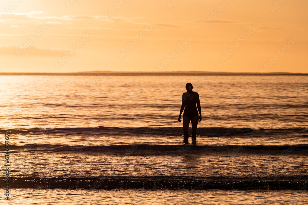 Silhouette of female swimmer going into the Atlantic ocean in Ireland