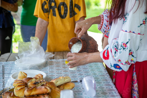 Women's hands with a jug pour matsun. Armenian national drink photo