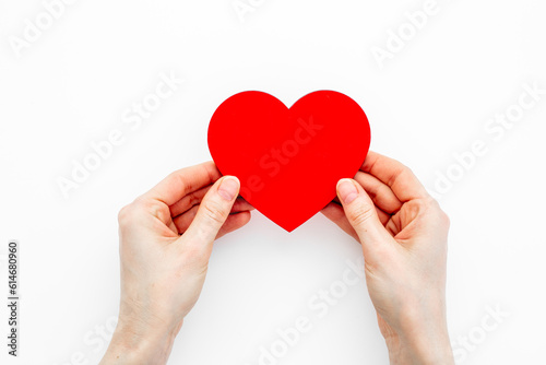 Red heart with woman hands, top view. Health care and love concept