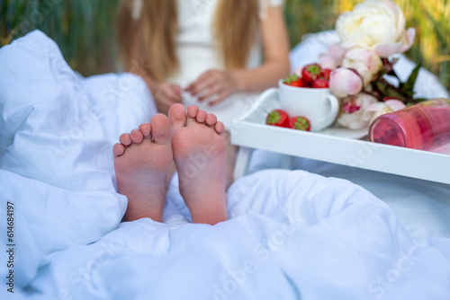 Children's feet on a white blanket at a picnic