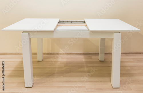 White table with sliding central part with white legs, furniture design