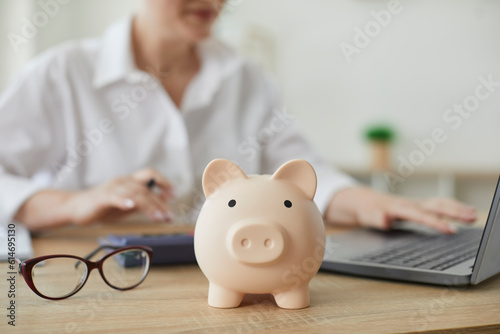 Piggy bank in form of pig on background of financial advisor who plans annual budget. Close up of piggy bank on table. Business, finance, investment, saving and corruption concept. photo
