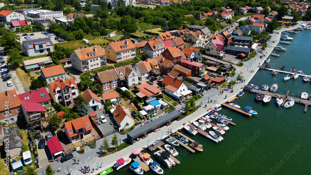 Panoramic aerial photo from drone to Mikolajki townscape - capital of Masurian region on the shore of the holiday resort beautiful summer afternoon. Mikolajki, Mikołajki, Poland, Europe.