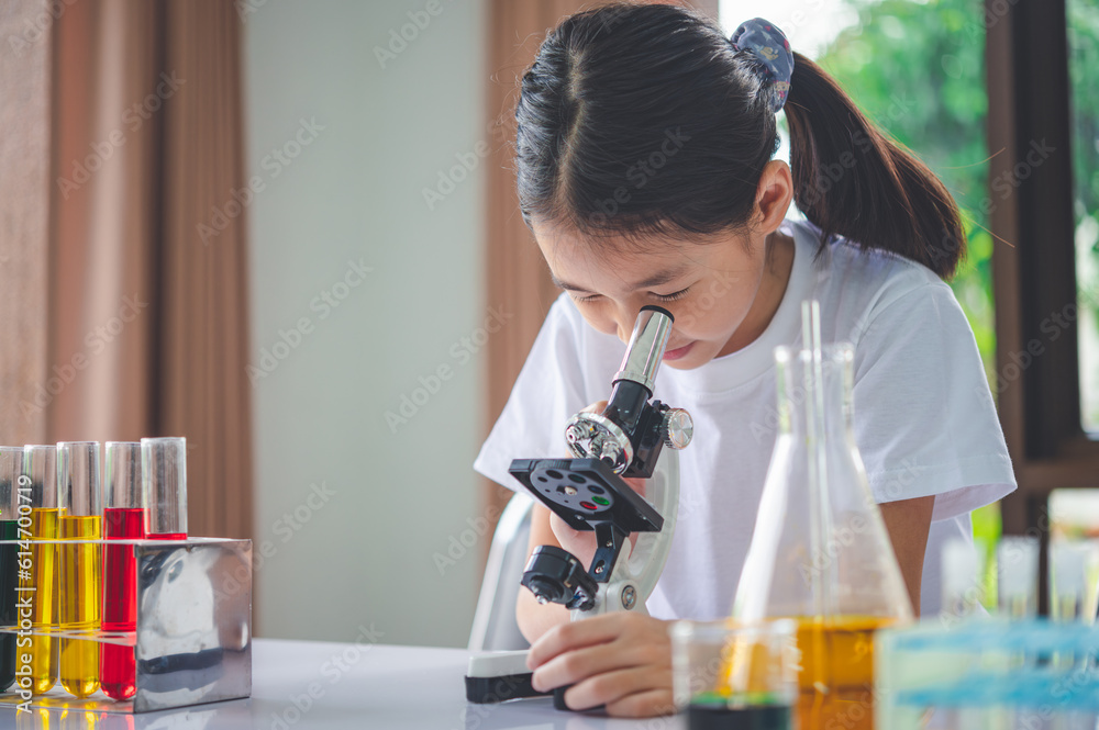 little scientist looking through a microscope and test tubes filled with chemicals for learning about science and experiments. little scientist looking through a microscope and test tubes filled with chemicals for learning about science and experiments.