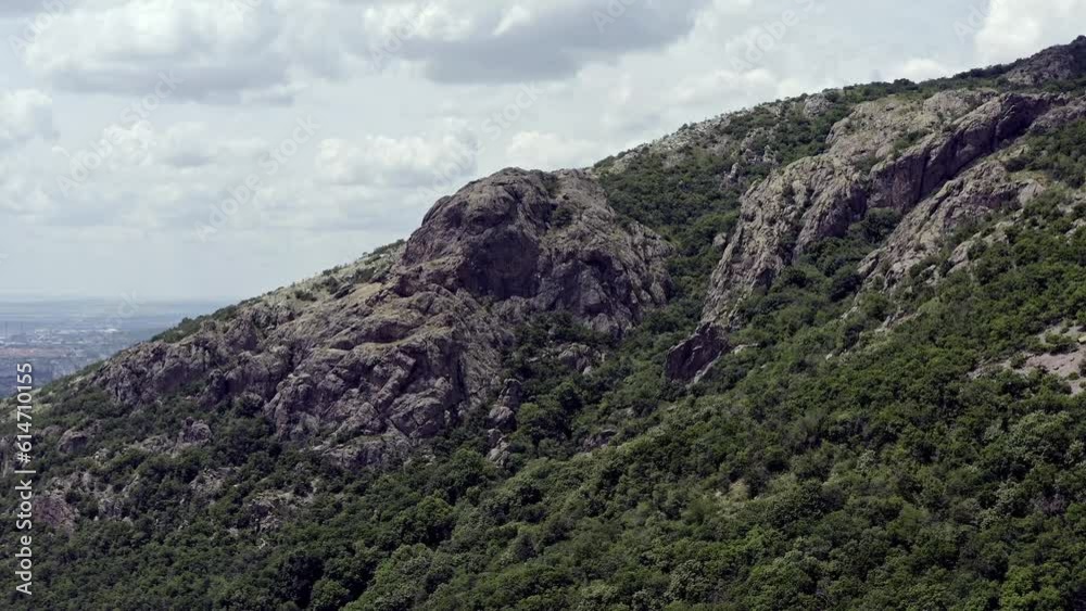 Drone flies to craggy rock formations on forested slopes of Balkan mountains Drone flies to craggy rock formations on forested slopes of Balkan mountains