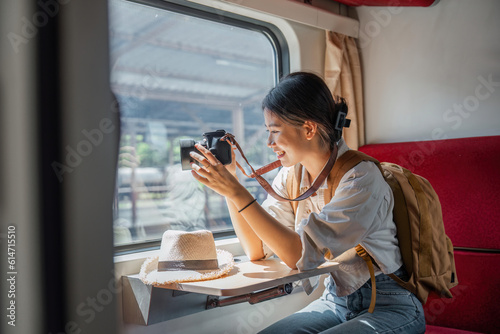 Beautiful Asian female tourist with sitting and take a photo travel location and sightseeing urban window view, public train transport, city lifestyle journey by railway