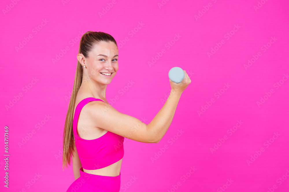 Sportswoman lifting weight and smiling at camera Sportswoman lifting weight and smiling at camera