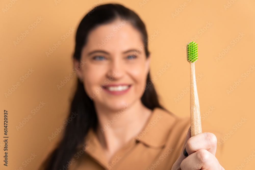 happy mature woman showing ecological tooth brush in all beige colors. biodegradable, hygiene concept. happy mature woman showing ecological tooth brush in all beige colors. biodegradable, hygiene concept.