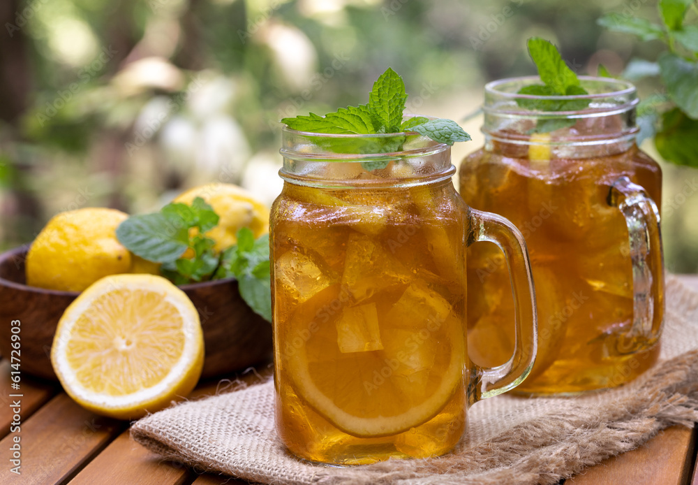 Ice tea in glass jars with lemon and mint Ice tea in glass jars with lemon and mint