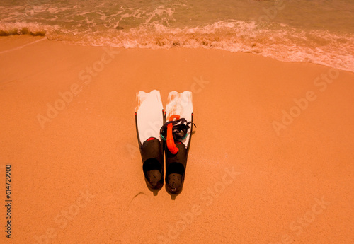 Flipper or fins with snorkel mask driving put on beach sand sea on holiday activity concept. photo