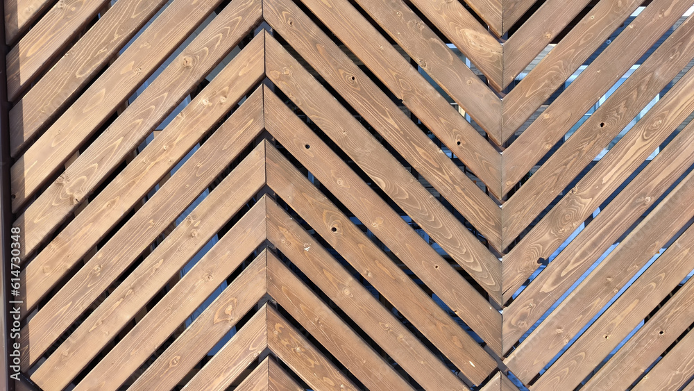 Fence made of wooden slats with a pattern in the shape of a fir tree as a Location, Background, texture, copy of space, frame. Abstract natural graphic resource Fence made of wooden slats with a pattern in the shape of a fir tree as a Location, Background, texture, copy of space, frame. Abstract natural graphic resource
