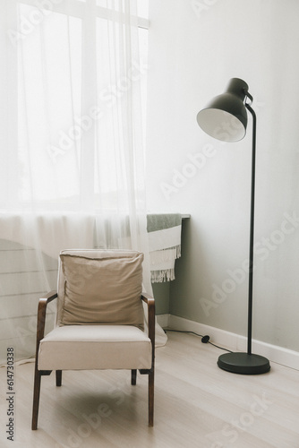 Armchair, luminous lamp, in the living room. Advertising blog about real estate and modern interiors, simple Scandinavian design