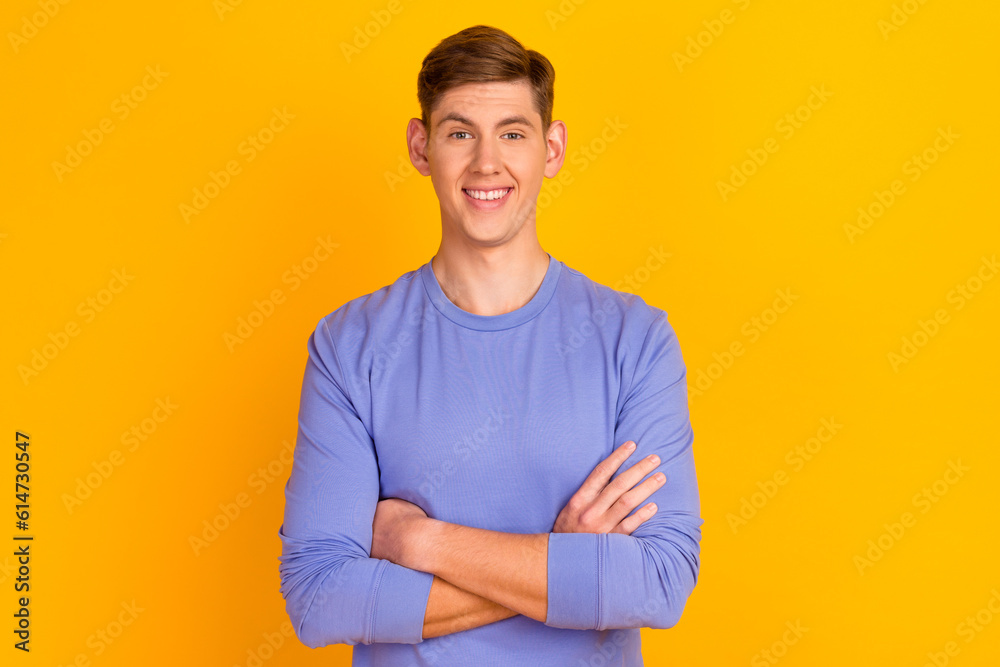Portrait of attractive wearing casual classic sweater macho man standing with folded arms isolated on yellow background Portrait of attractive wearing casual classic sweater macho man standing with folded arms isolated on yellow background
