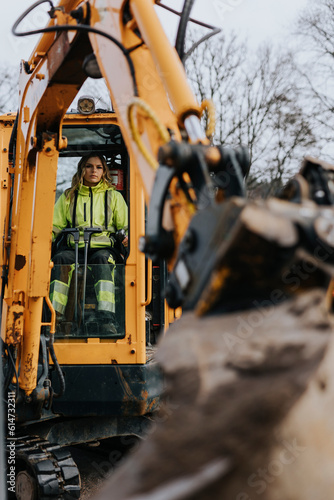 Female road worker operating excavator
