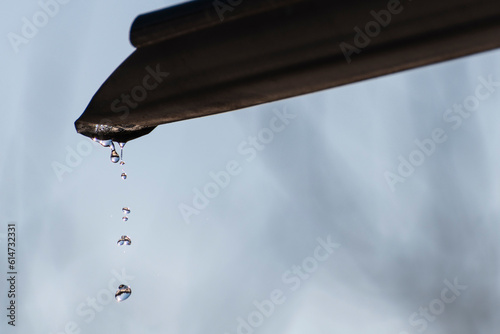 Rain drops dripping from gutter photo