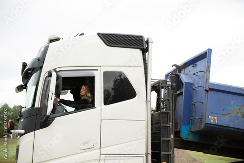 Woman driving long-distance lorry preparing to tipping off the load photo