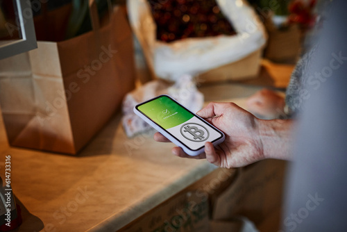 Person paying with bitcoin crypto currency for groceries photo