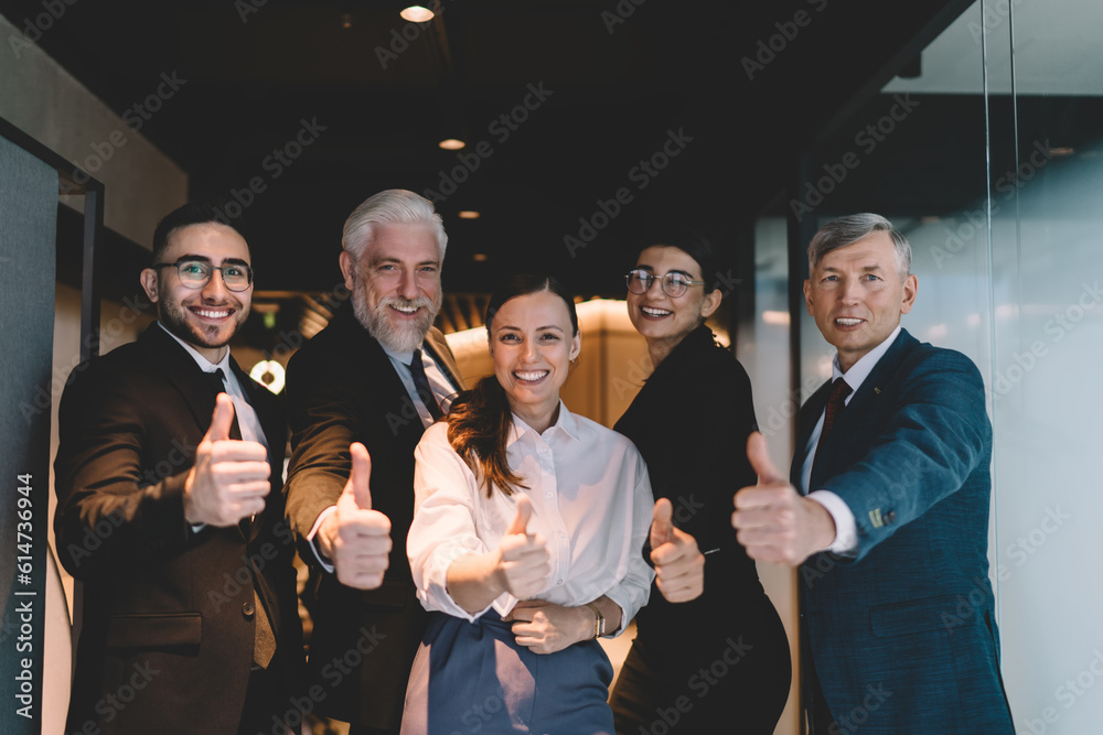 Group of colleagues with thumbs up in corridor