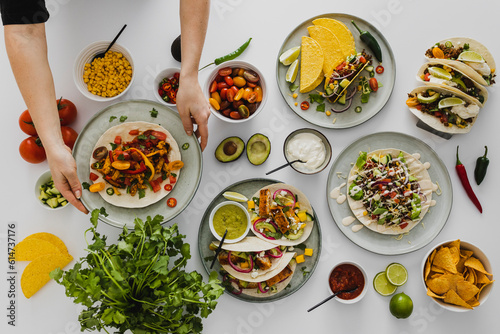 Person preparing healthy feast with various Mexican food photo