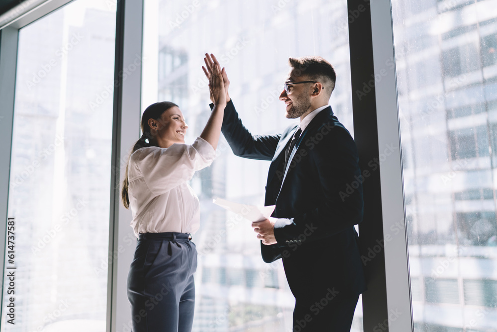 Cheerful multiethnic colleagues giving high five Cheerful multiethnic colleagues giving high five