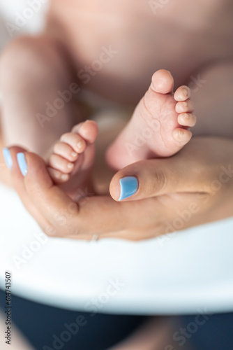 Close-up  the feet of a newborn in the hands of the mother.