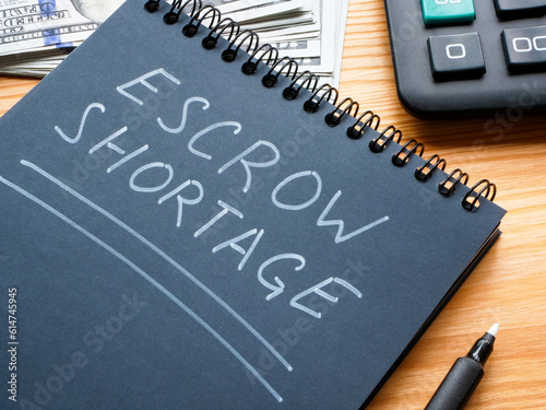 The entry Escrow shortage was made in a notebook with a white marker.