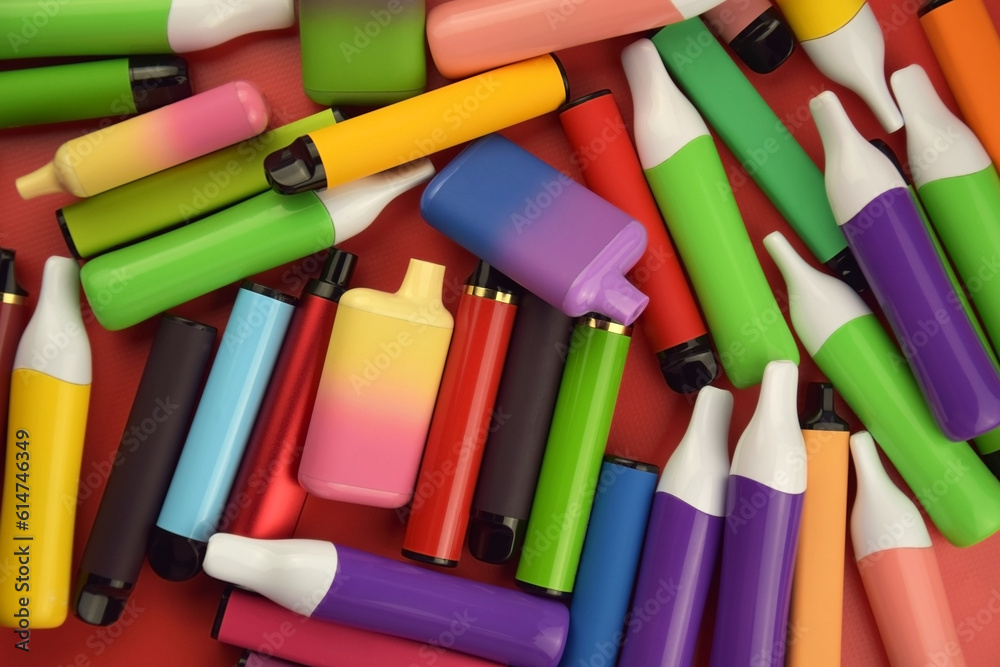 Set of multicolor disposable electronic cigarettes on a red background. Set of multicolor disposable electronic cigarettes on a red background.