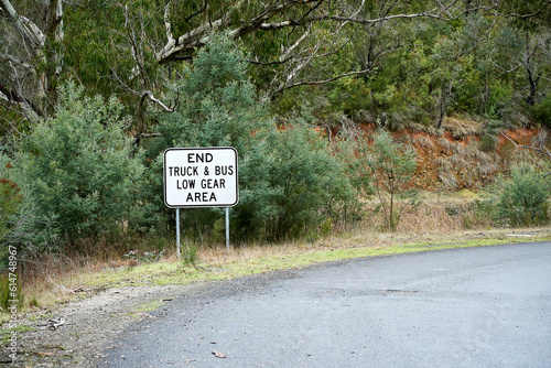 Road Sign at the end of a steep descent indicating Trucks and Buses no longer need to use low gear