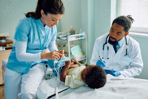 African American kid during electrocardiogram test at doctor's office.