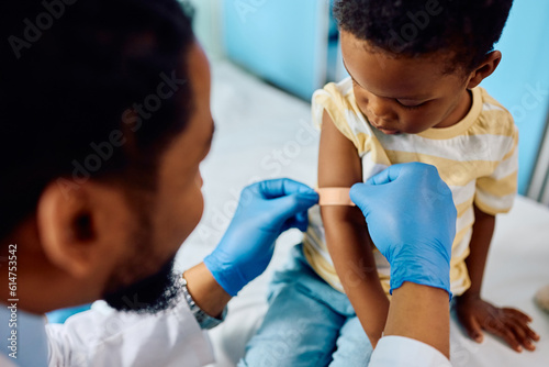 Photography Close up of black kid getting band aid after vaccination at pediatrician's