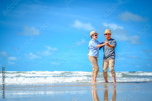 Plan life insurance of happy retirement concepts. Senior couple dancing at the beach looking the ocean on a good day in sunny day morning.