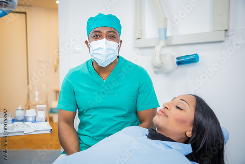 An African dentist in the clinic with a female patient during a dental visit