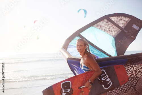 Foto Portrait woman carrying kiteboard equipment on beach