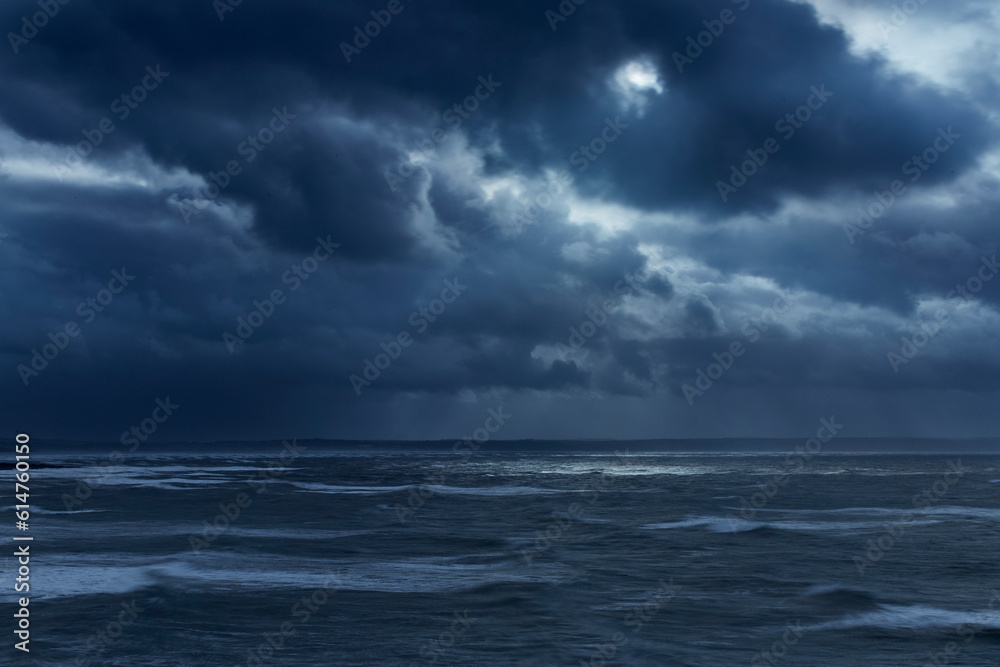 Dark clouds in overcast sky over stormy ocean, Devon, United Kingdom