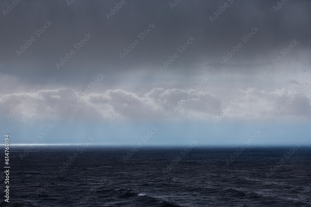 Clouds and rain over ocean seascape