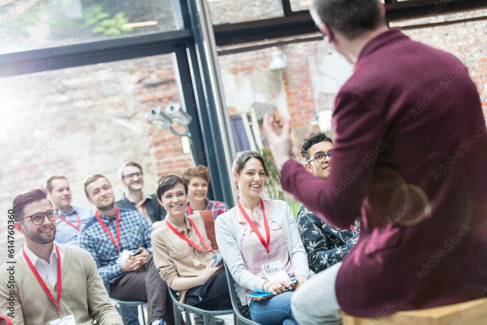 Smiling audience watching presentation at conference