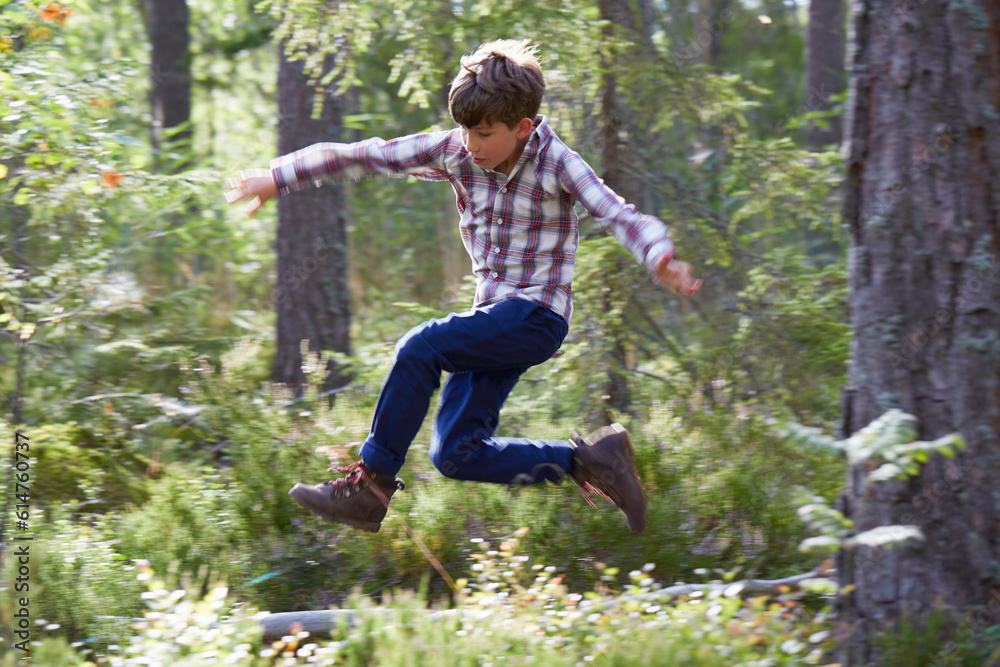 Energetic boy jumping in woods