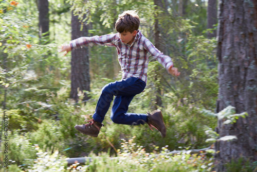 Energetic boy jumping in woods