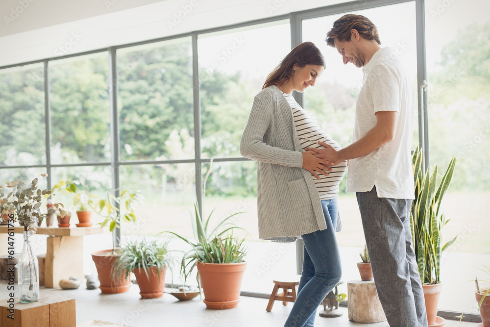 Pregnant couple holding stomach Pregnant couple holding stomach