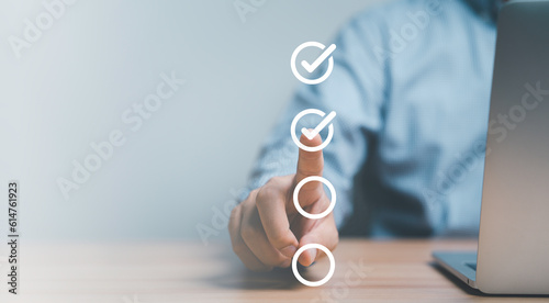 Businessman hand point to tick correct sign mark in checkbox for quality document control checklist and business approve project concept. photo