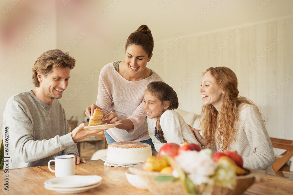 Woman serving cake to family at dining table