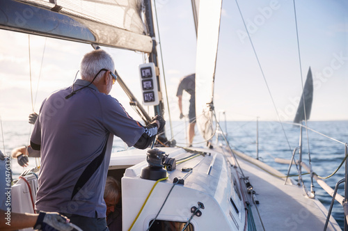 Man adjusting sailing equipment on sailboat