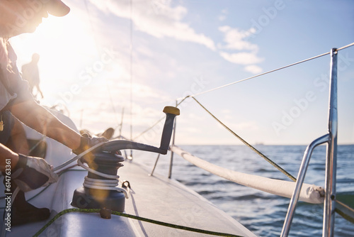 Man adjusting sailing winch on sailboat photo