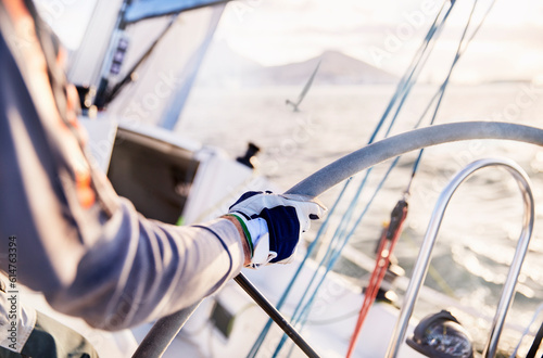 Fotografie Man sailing steering sailboat at helm