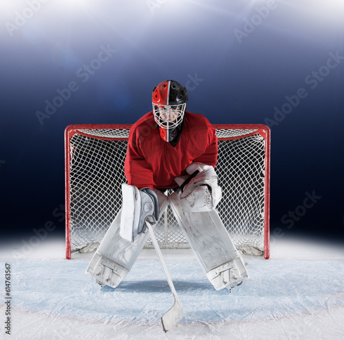 Portrait determined hockey goalie protecting goal net on ice